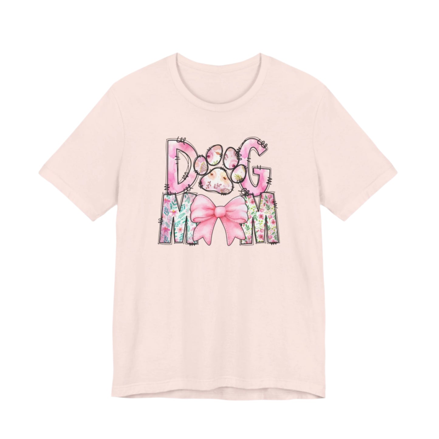 Celebrate your love for dogs with the Banks + Cove Paws & Petals Dog Mom T-Shirt, featuring watercolor florals, a pink bow, and a charming Dog Mom design, complete with an adorable paw print.