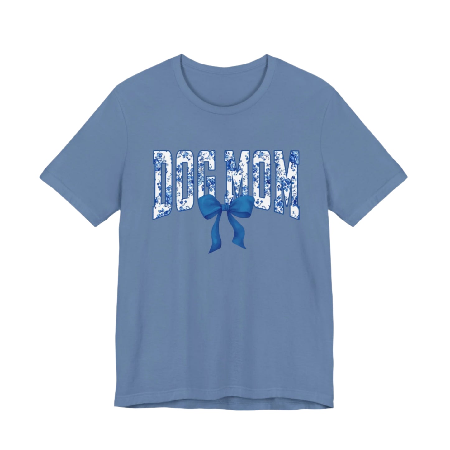 The Banks + Cove Dog Mom Blue T-Shirt features Dog Mom in floral-patterned white letters with a large, charming blue bow beneath.
