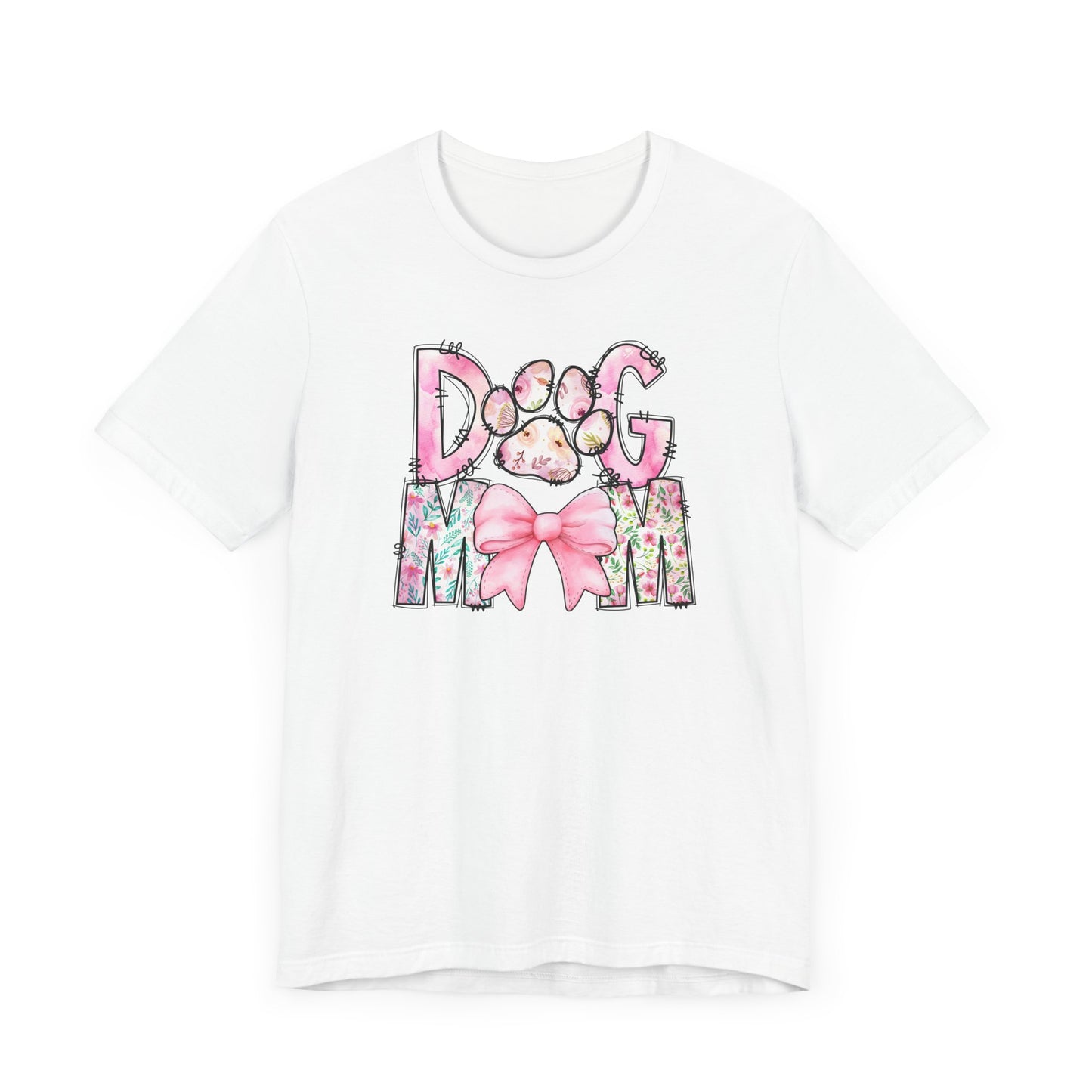 Introducing the Paws & Petals Dog Mom T-Shirt by Banks + Cove: this white tee features DOG MOM text with a pink paw print and bow, elegantly decorated with watercolor florals, perfect for any proud dog lover.
