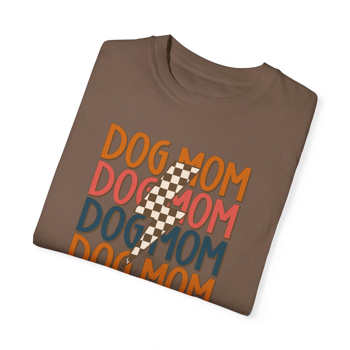 The Checkered Vibes Dog Mom Tee by Banks + Cove is a retro-style brown shirt featuring vibrant orange, red, and blue Dog Mom text with an energizing checkered lightning bolt, ideal for trendy dog moms exuding true Dog Mom Energy.