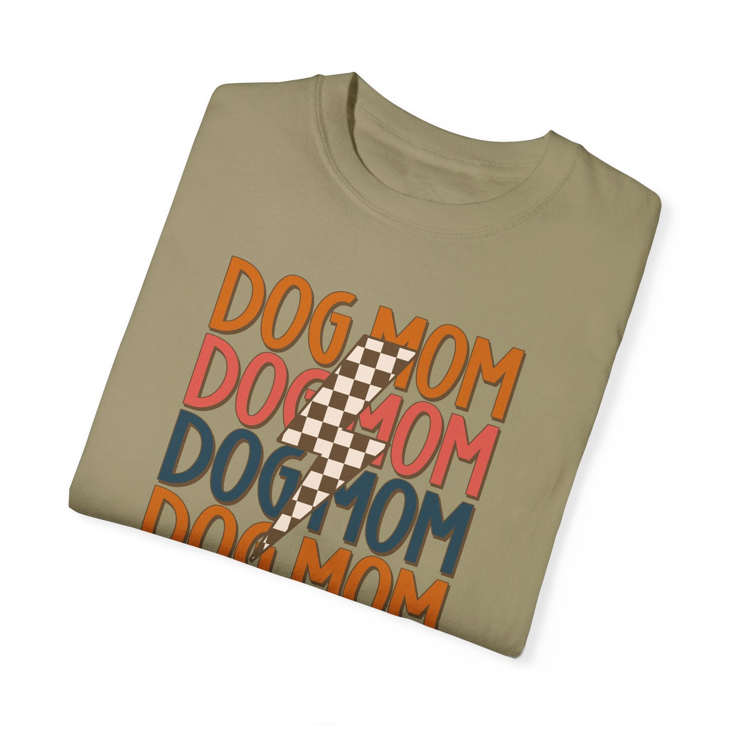 The Banks + Cove Checkered Vibes Dog Mom Tee is a retro olive green shirt with DOG MOM in orange, blue, pink, and brown. It features a chic brown and white checkered lightning bolt overlay. Perfect for trendy dog moms who want to embrace their Dog Mom Energy!.