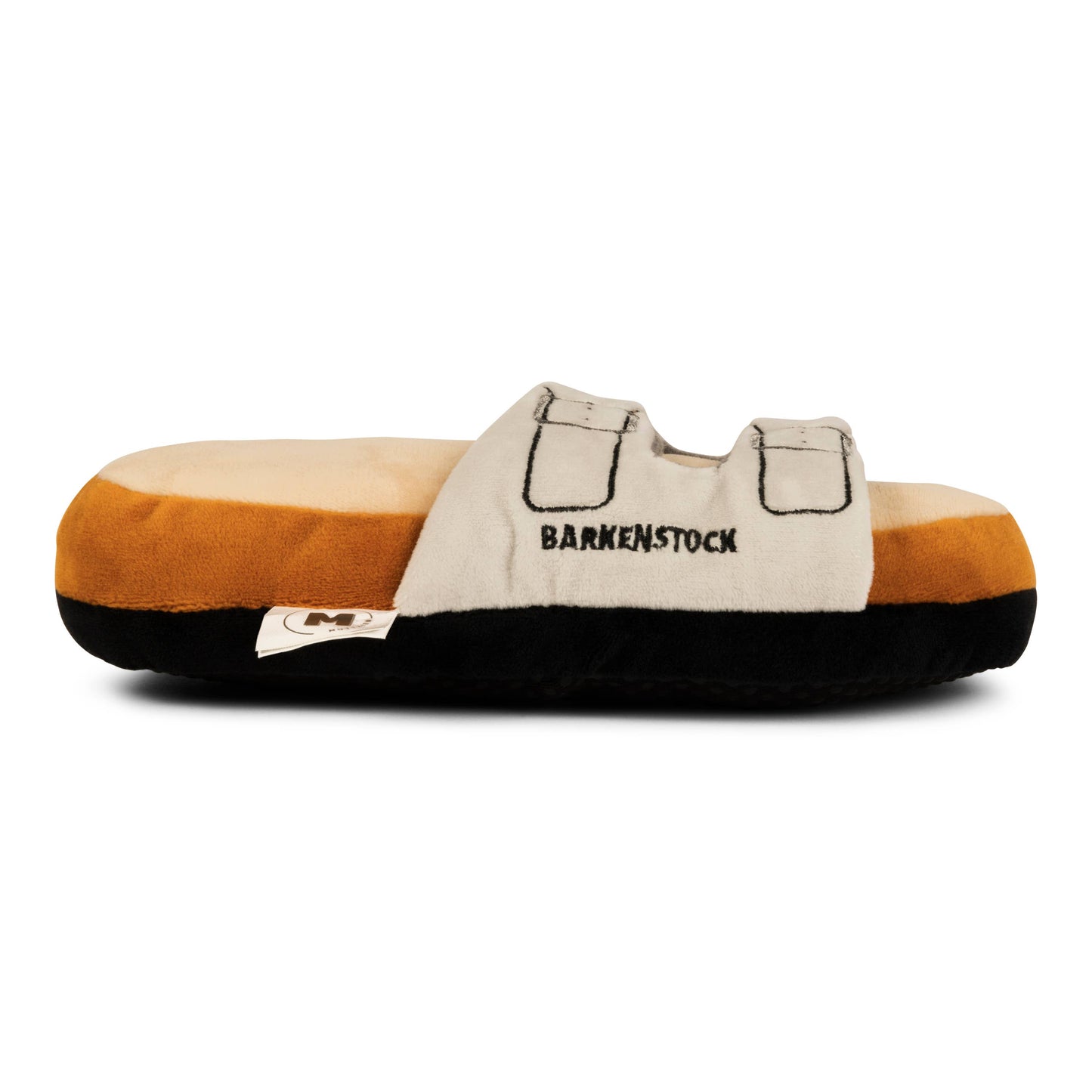 The Barkenstock Sandal Toy by Muttzie is a plush slipper designed as a beige sandal with two black BARKENSTOCK straps. Its brown base mimics a cushioned sole and includes double squeakers for fun!.