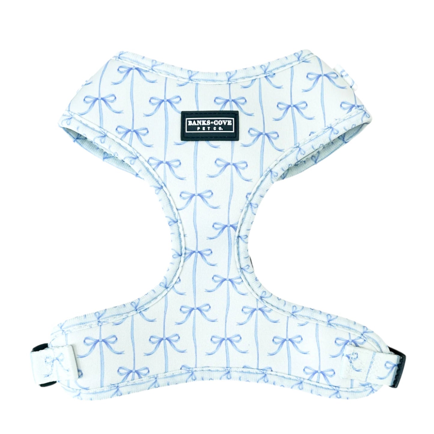 The Distinguished Gentlepup Dog Harness by Banks + Cove features a charming blue bow pattern on a white backdrop and an elegantly stitched BARKLEY & POOFE PETCO label, adding sophistication to your pets ensemble.