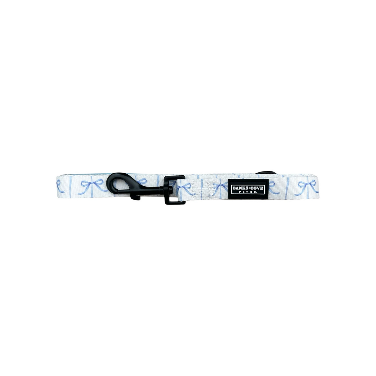 Displayed is the Distinguished Gentlepup Dog Collar by Banks + Cove, a stylish white collar with light blue bow patterns. It features a durable black buckle clasp and tag. Lying flat on a white background, it perfectly matches its leash.