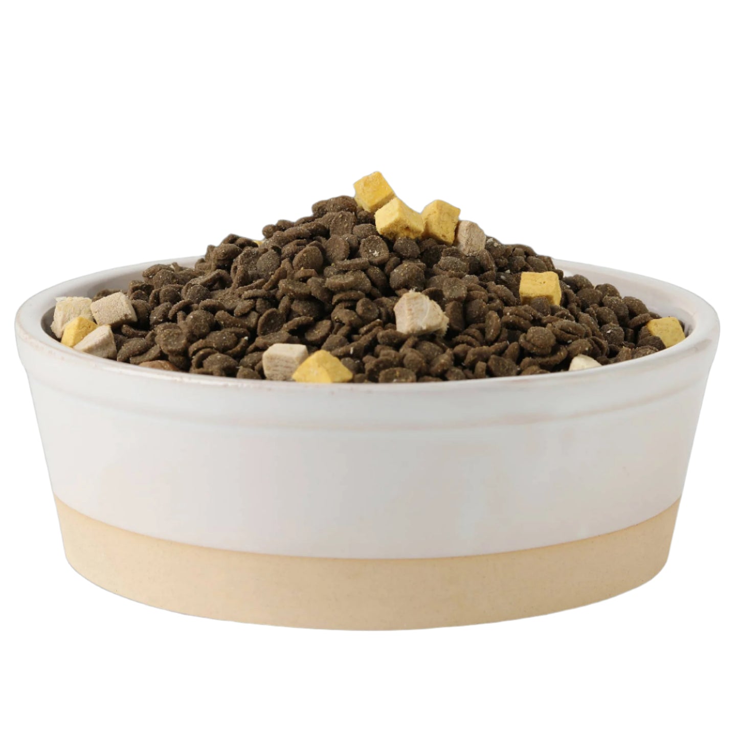 The Nordic Cream Pet Bowl by Park Life Designs, with its stylish white ceramic top and potters clay base, is filled with dry pet food kibble featuring small cube-shaped pieces in yellow and beige. The design is captured from a side angle against a plain white background.