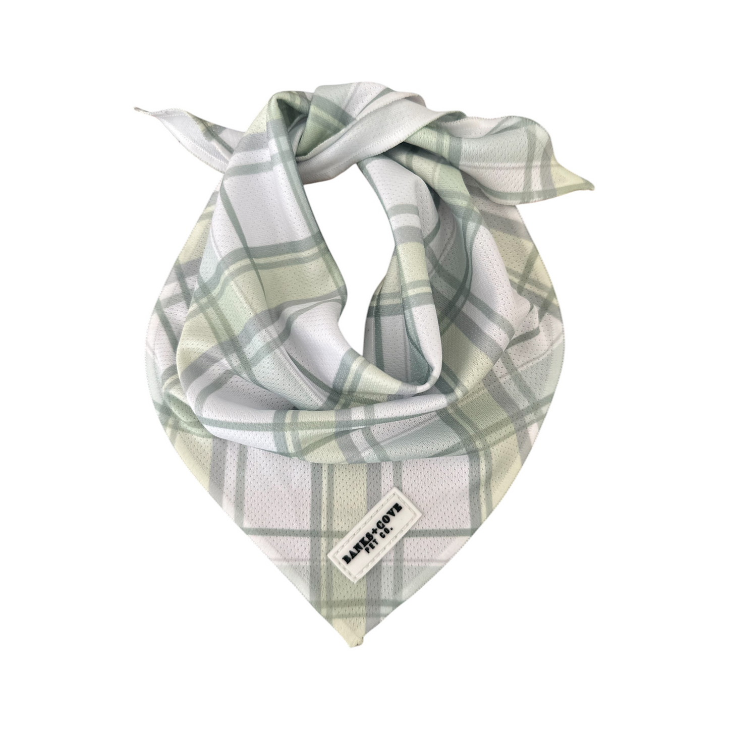 The Plaid About You Bandana by Banks + Cove is a green and white plaid piece folded into a triangle, adding timeless style to your pups wardrobe. It features a small label with text sewn onto one corner.
