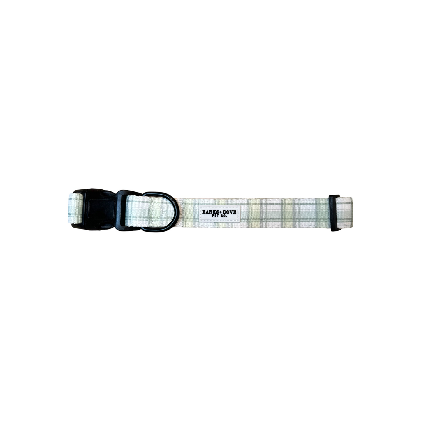 The Plaid About You Dog Collar by Banks + Cove is a white and light green plaid collar made from durable, lightweight materials with a black buckle and metal ring. It includes a small label and offers an adjustable fit, displayed flat on a white background.