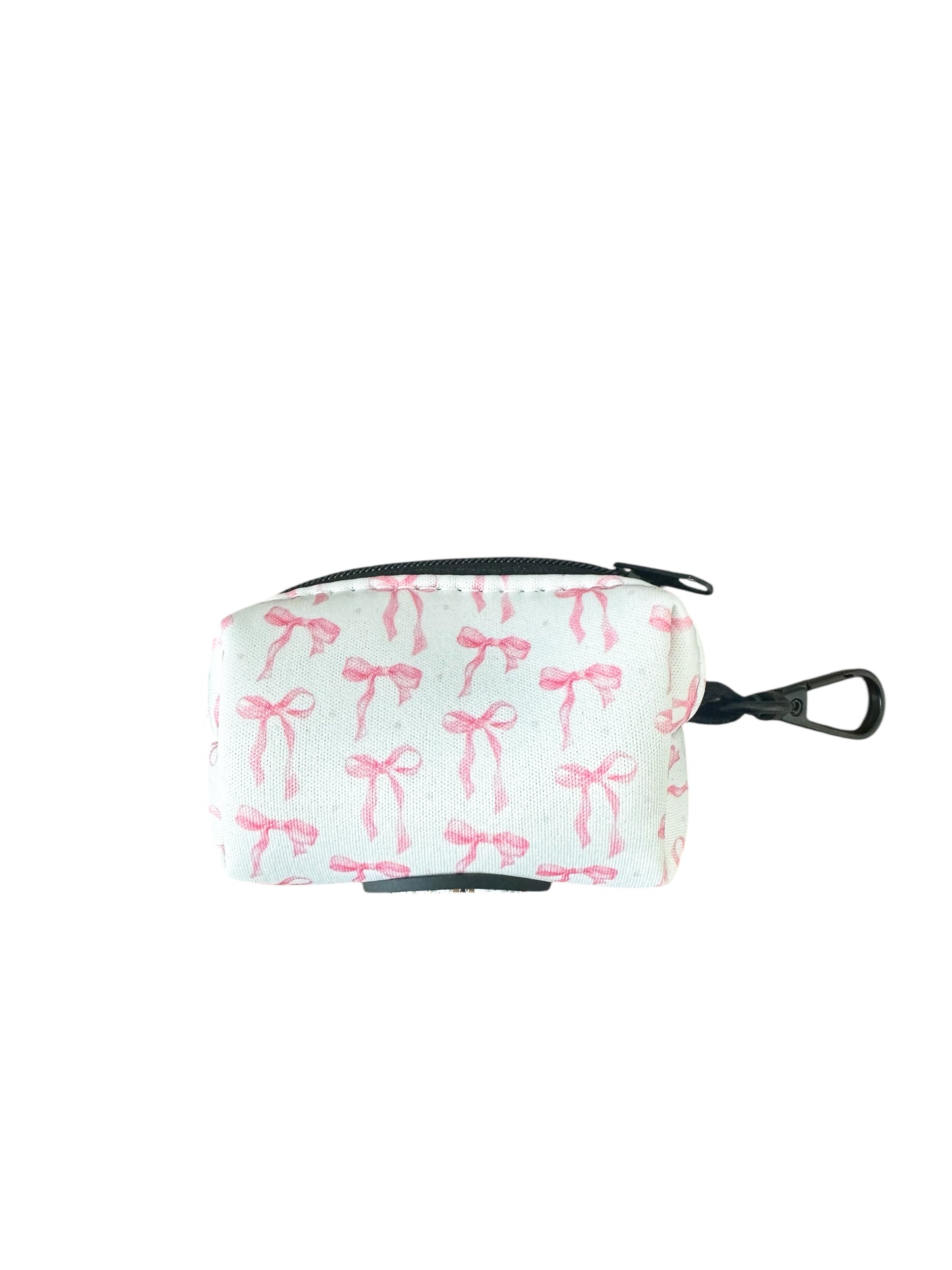 Banks + Coves The Coquette Pooch-Waste Bag Holder is a small, rectangular cotton pouch with a zipper and metal clip. Elegant and practical, this fashionable dog accessory features a pattern of pink bows on a light background.