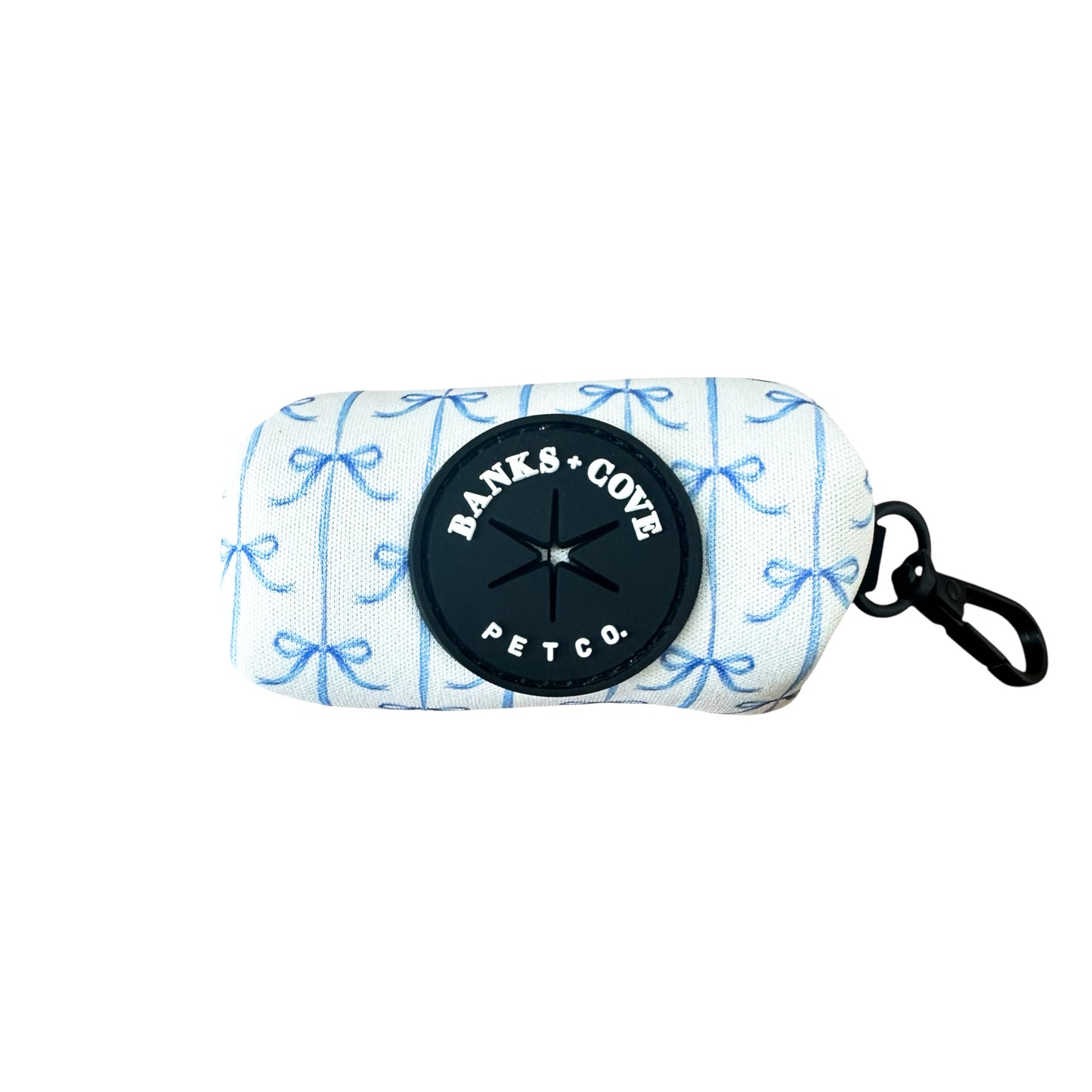 The Banks + Cove Distinguished Gentlepup Waste Bag Holder is a rectangular fabric pouch with a white background and light blue bow pattern. It features a black rubber logo and includes a black clip on the right side for leash attachment and waste bag holding.