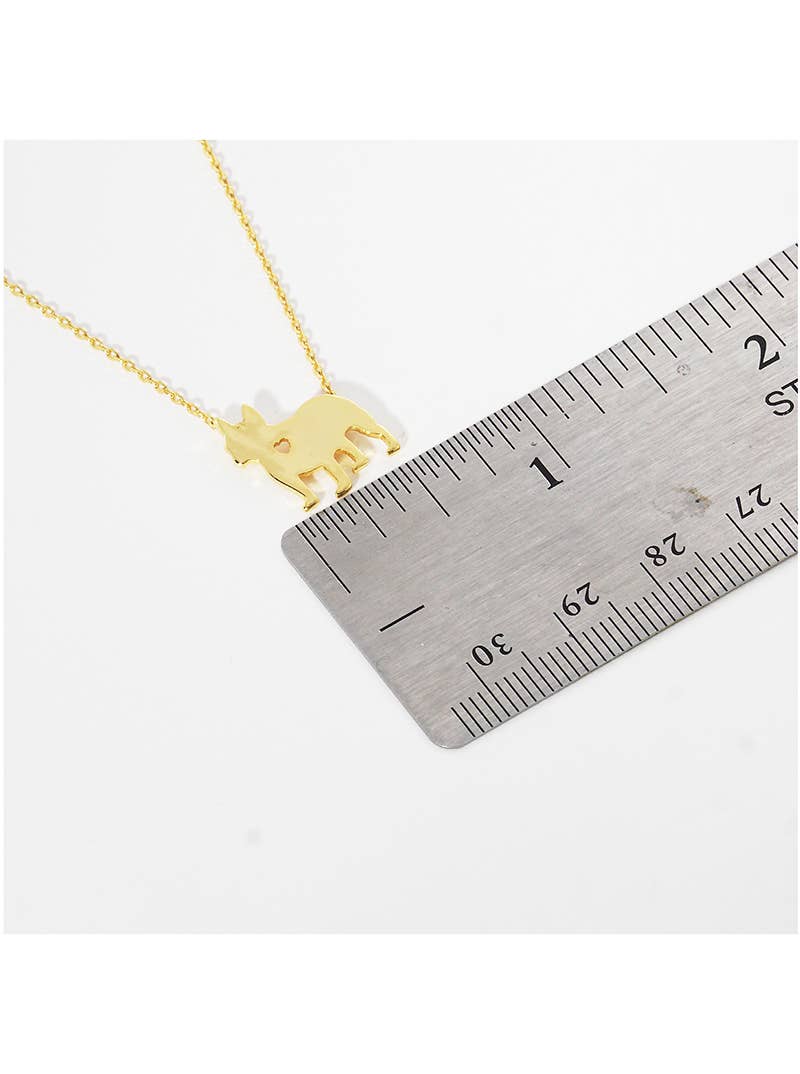 The Frenchie Love Necklace by Banks + Cove features a gold-tone donkey-shaped pendant, approximately 2 centimeters in size, resting beside a metal ruler. Its chain is composed of small round links and elegantly lays on a plain white surface—ideal for any dog mom accessory collection.