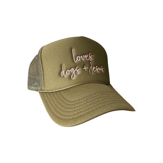 The Banks + Cove Loves Dogs + Jesus hat blends fashion and faith with its olive green mesh-back design, featuring stylish embroidered cursive in white and pink on the front panel.
