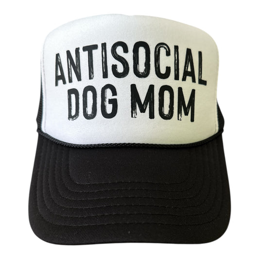 The Banks + Cove Antisocial Dog Mom Trucker Hat features bold black ANTISOCIAL DOG MOM lettering on a classic black and white Otto cap—ideal for dog moms who love to stand out.