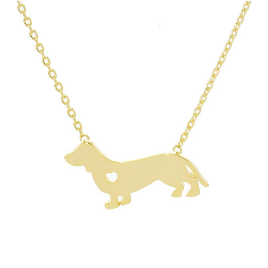 The Dachshund Love Necklace by Banks + Cove showcases a gold-tone dachshund pendant with a heart cutout on a delicate chain, ideal for dog lovers.