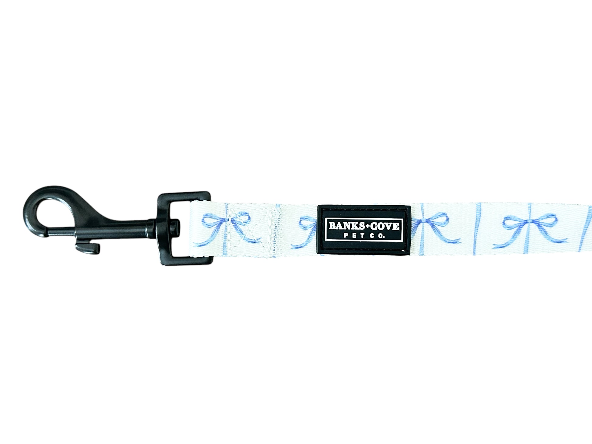 Meet the Distinguished Gentlepup Dog Leash from Banks + Cove: a light blue leash with charming bow patterns, a sturdy black clip, and a sleek black label reading Banks & Cove Pet Co, making it the ideal stylish accessory for your pampered pooch.