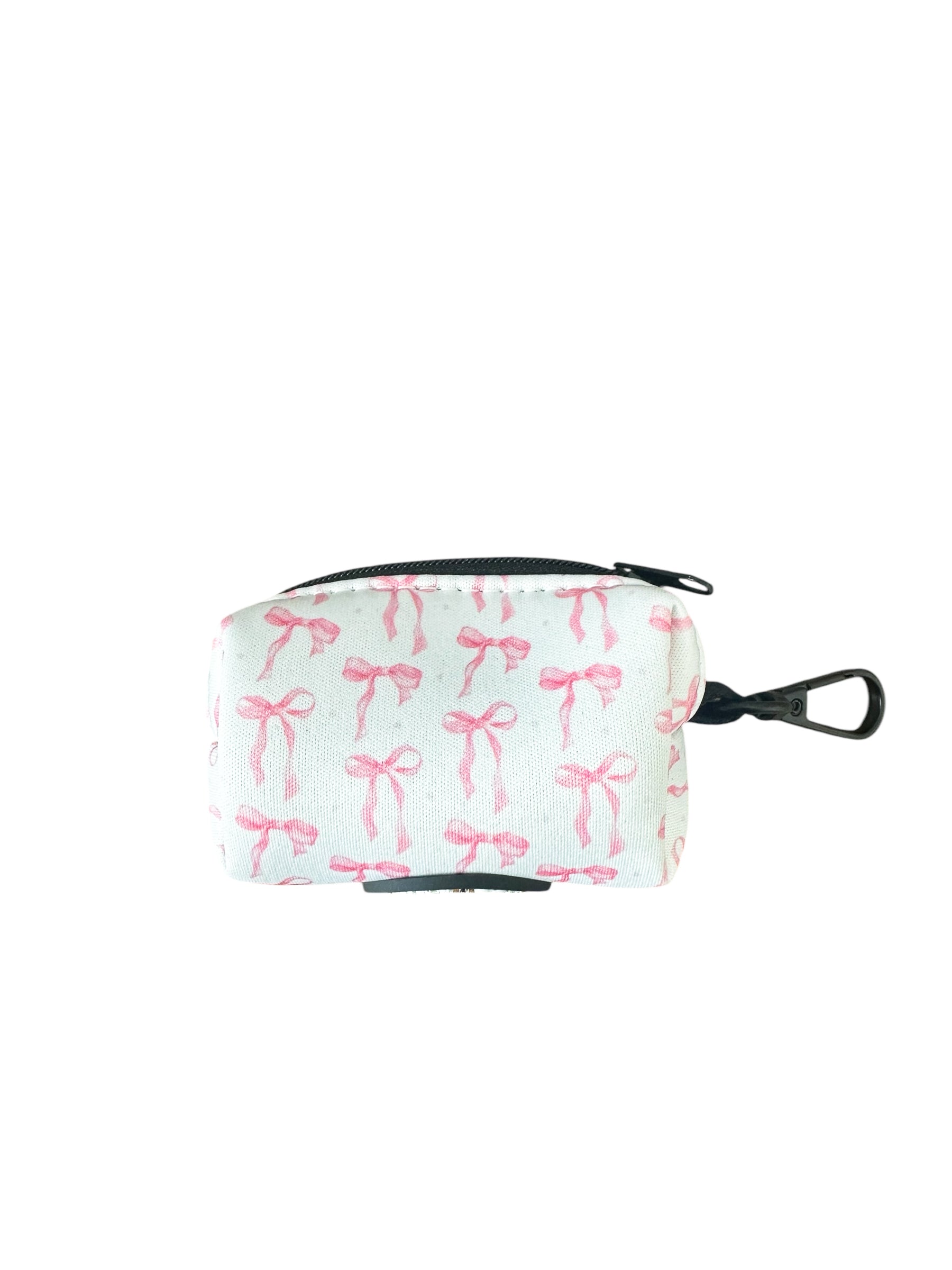 Banks + Coves The Coquette Pooch-Waste Bag Holder is a small, rectangular cotton pouch with a zipper and metal clip. Elegant and practical, this fashionable dog accessory features a pattern of pink bows on a light background.